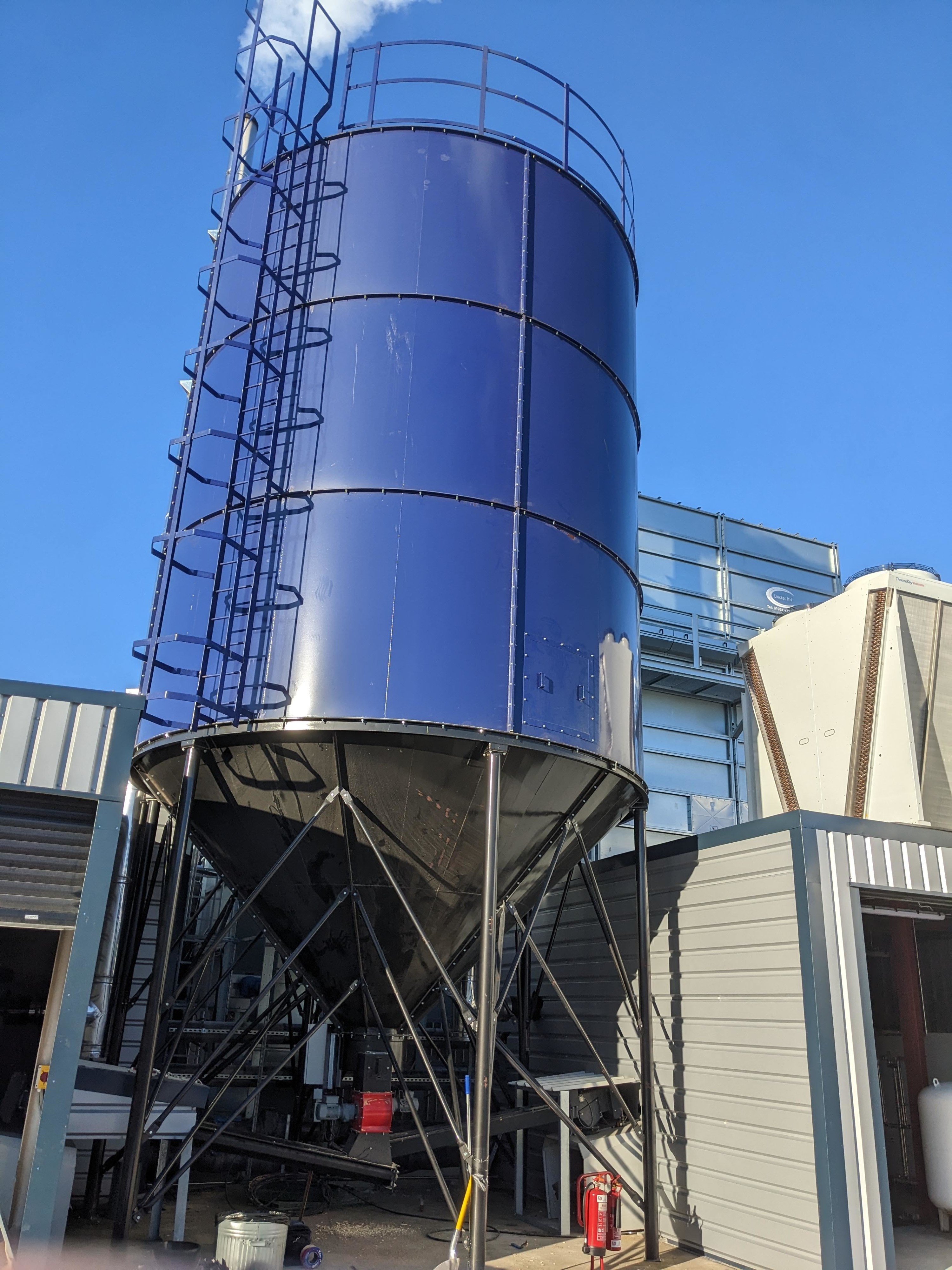 5-metre, 3-ring Ranheat C120 industrial wood waste silo installed at a staircase manufacturing facility.